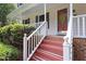 Close up of porch with bright white railings and red stairs that lead to the front door at 905 Balmoral Dr, Cary, NC 27511