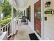 Charming front porch with seating and a red front door with decorative glass at 905 Balmoral Dr, Cary, NC 27511