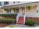 Inviting front porch with white railings, red stairs, and manicured landscaping at 905 Balmoral Dr, Cary, NC 27511