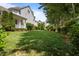 Spacious backyard with lush lawn, mature trees, and landscaping offers a serene outdoor setting at 100 Maywood Way, Chapel Hill, NC 27516
