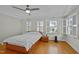 Bedroom with hardwood floors, white walls, shuttered windows, and a ceiling fan at 100 Maywood Way, Chapel Hill, NC 27516