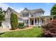Charming two-story home with a welcoming front porch, landscaped yard, and attached two-car garage at 100 Maywood Way, Chapel Hill, NC 27516
