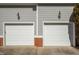 Two-car garage doors on a gray home with brick accents and carriage lights at 100 Maywood Way, Chapel Hill, NC 27516