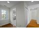 Hallway showing wood floors, a window, and white doors at 100 Maywood Way, Chapel Hill, NC 27516