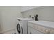 Well-lit laundry room featuring modern washer and dryer set and storage above at 100 Maywood Way, Chapel Hill, NC 27516