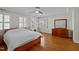 Main bedroom with hardwood floors, shuttered windows, tray ceiling, and dresser at 100 Maywood Way, Chapel Hill, NC 27516