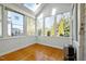 Bright sunroom features hardwood floors, neutral paint and floor to ceiling windows at 100 Maywood Way, Chapel Hill, NC 27516