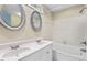 Bright bathroom with double sinks, white cabinets, and a bathtub with tile surround at 1014 Laurens Way, Knightdale, NC 27545
