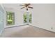 Large bedroom with neutral carpet, ceiling fan, and windows with wooded views at 1014 Laurens Way, Knightdale, NC 27545