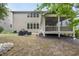Backyard featuring lush greenery, mature trees, covered outdoor grills, and screened porch at 1029 Dozier Way, Cary, NC 27518