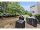 Partially shaded backyard featuring lush greenery, mature trees and covered outdoor grills at 1029 Dozier Way, Cary, NC 27518