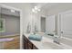 Bright bathroom with double sinks, a large mirror, and a view into an adjacent room at 1029 Dozier Way, Cary, NC 27518