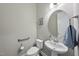 A powder room with a pedestal sink, a toilet, and an elegant round mirror at 1029 Dozier Way, Cary, NC 27518