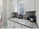 A coffee bar features granite countertops, stainless steel appliances, and white cabinets at 1029 Dozier Way, Cary, NC 27518
