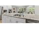 Kitchen island with granite countertops and stainless steel sink overlooking the eating area at 1029 Dozier Way, Cary, NC 27518