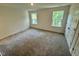 A bright bedroom with carpet, a neutral color palette, and two windows that bring in natural light at 10517 Brookside Reserve Rd, Raleigh, NC 27614