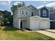 Modern two-story townhouse with gray and blue siding, a garage, and a green lawn at 10517 Brookside Reserve Rd, Raleigh, NC 27614