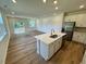 Open-concept living space with wood floors, kitchen island, and bright natural light at 10517 Brookside Reserve Rd, Raleigh, NC 27614