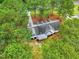 Stunning aerial view of a home nestled among lush trees, highlighting its unique roofline and serene setting at 106 Eagle Crest Ln, Princeton, NC 27569