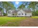 Backyard view of the home with a porch, lawn, and mature trees at 106 Eagle Crest Ln, Princeton, NC 27569