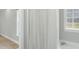 Bathroom featuring white tub, decorative shower curtain and decorative glass block window at 106 Eagle Crest Ln, Princeton, NC 27569