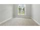 Bright bedroom featuring plush carpeting and arched window with backyard view at 106 Eagle Crest Ln, Princeton, NC 27569