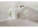 A carpeted bonus room with two large windows, a ceiling fan, and a cooling system at 106 Eagle Crest Ln, Princeton, NC 27569