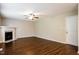A cozy living room with a fireplace, ceiling fan, and rich wood-look floors at 107 Kimeo Way, Garner, NC 27529