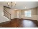 Open living room view with staircase, chandelier, and wood-look floors at 107 Kimeo Way, Garner, NC 27529