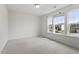 A spacious bedroom with plush carpet and three windows providing natural light and neighborhood views at 110 Gallery Park Dr, Franklinton, NC 27525