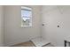 A bright laundry room featuring a window, overhead shelving, and utility hookups at 110 Gallery Park Dr, Franklinton, NC 27525