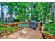 Wooden back deck with a grill, garden, and string lights strung between the trees at 113 Fetzer Ct, Cary, NC 27513