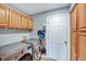 Laundry room featuring a modern washer and dryer set with oak cabinets for extra storage at 113 Fetzer Ct, Cary, NC 27513