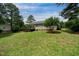 View of the backyard featuring the home's rear facade, a wooden deck, and a large grassy lawn at 117 Rack Ct, Willow Springs, NC 27592