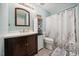 Updated bathroom with a dark wood vanity, white countertop, matching storage, and shower with patterned curtain at 117 Rack Ct, Willow Springs, NC 27592