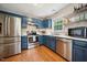 Updated kitchen with stainless steel appliances, blue cabinets, and light countertops at 117 Rack Ct, Willow Springs, NC 27592