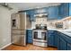 Updated kitchen showcasing stainless steel refrigerator, oven, and blue cabinets at 117 Rack Ct, Willow Springs, NC 27592