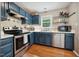 Updated kitchen featuring stainless steel oven, dishwasher and blue cabinets at 117 Rack Ct, Willow Springs, NC 27592