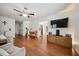 Bright living room features hardwood floors, ceiling fan, and large windows offering a cozy and inviting atmosphere at 117 Rack Ct, Willow Springs, NC 27592