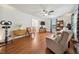 Bright living room features hardwood floors, ceiling fan, and large windows offering a cozy and inviting atmosphere at 117 Rack Ct, Willow Springs, NC 27592
