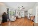 Bright living room features hardwood floors, ceiling fan, and large windows offering a cozy and inviting atmosphere at 117 Rack Ct, Willow Springs, NC 27592