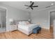 A bright bedroom with wood floors features a ceiling fan and a large bed with white bedding at 120 Hazel Alder Ct, Holly Springs, NC 27540