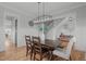 Inviting dining room featuring hardwood floors, wainscoting, and a stylish chandelier at 120 Hazel Alder Ct, Holly Springs, NC 27540