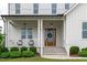Inviting front porch with a decorative wreath on the door, complemented by lush green landscaping at 120 Hazel Alder Ct, Holly Springs, NC 27540