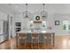Modern kitchen features large island, stainless appliances, and stylish pendant lighting at 120 Hazel Alder Ct, Holly Springs, NC 27540