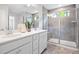 Bright bathroom features a double sink vanity and glass enclosed shower with a built-in seat and a window at 1213 Everton Ave, Durham, NC 27703