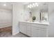 Bright bathroom featuring dual sinks, white cabinetry, modern fixtures, and plenty of counter space at 1213 Everton Ave, Durham, NC 27703