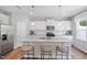 Bright kitchen featuring stainless steel appliances, white cabinets, granite countertops, and a large center island at 1213 Everton Ave, Durham, NC 27703
