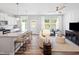 Open-concept living area with a kitchen island, comfortable seating, large windows, and modern decor at 1213 Everton Ave, Durham, NC 27703
