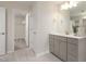 Bright bathroom featuring modern vanity, large mirror, and view into a walk-in closet with carpeted floor at 1215 Everton Ave, Durham, NC 27703